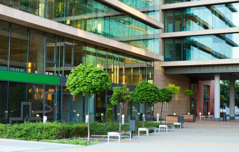 A building with many trees and bushes in front of it